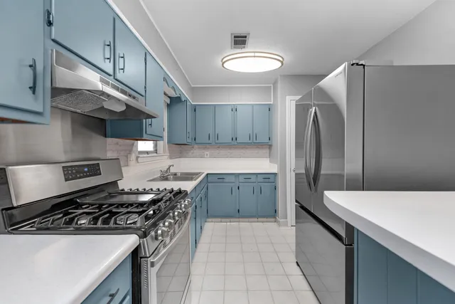 a kitchen with stainless steel appliances a sink stove and refrigerator