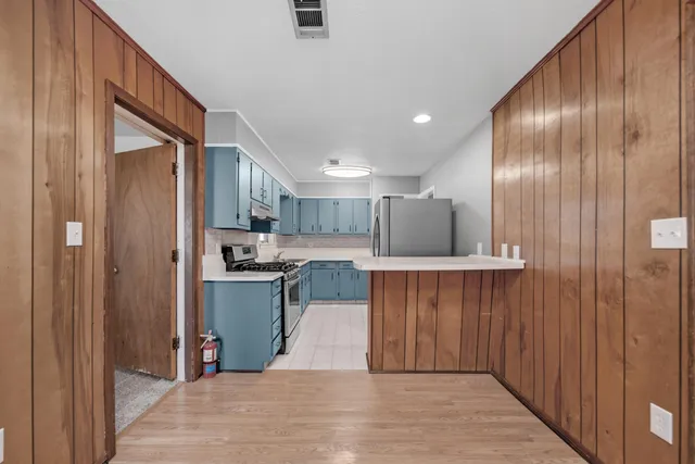 a kitchen with stainless steel appliances kitchen island granite countertop a refrigerator a sink and a microwave