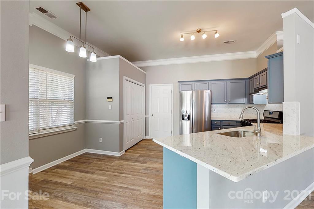 15387 Leslie Brooke Road Huntersville, NC 28078 - Photo 11 of 37 a kitchen with kitchen island a counter top space appliances and a sink