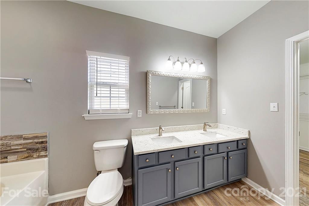 15387 Leslie Brooke Road Huntersville, NC 28078 - Photo 20 of 37 a bathroom with a toilet a sink a mirror and a window
