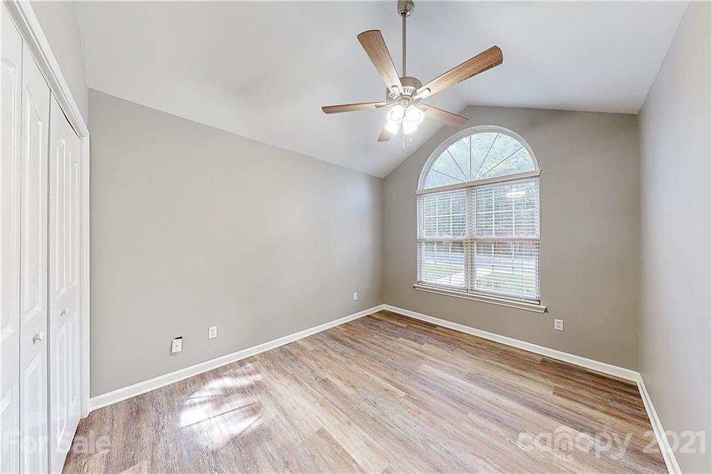 15387 Leslie Brooke Road Huntersville, NC 28078 - Photo 21 of 37 an empty room with wooden floor fan and windows