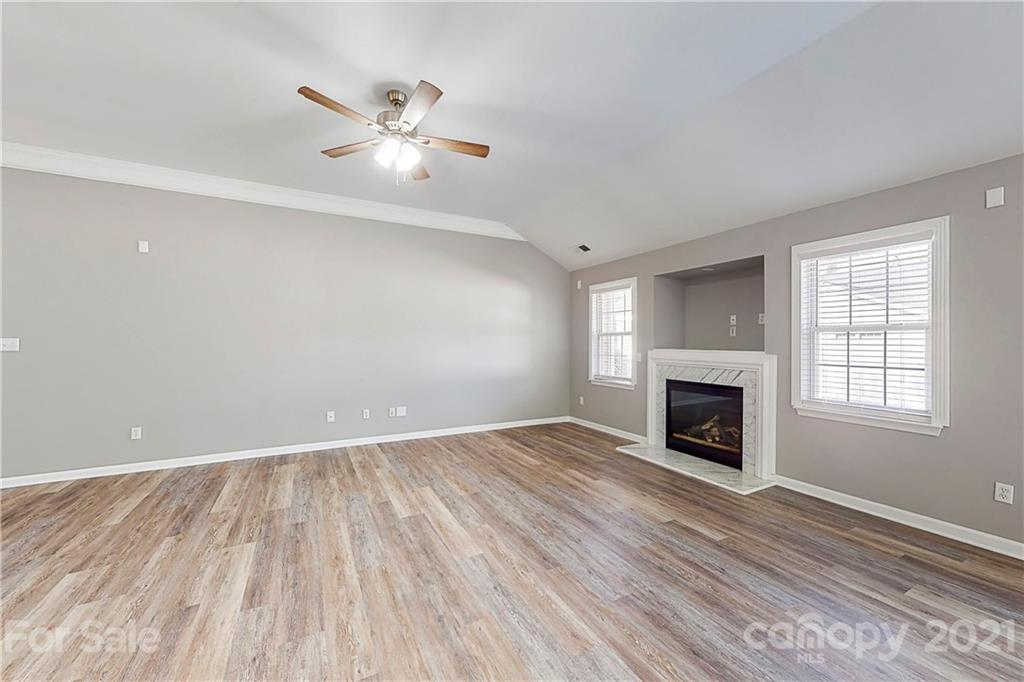 15387 Leslie Brooke Road Huntersville, NC 28078 - Photo 5 of 37 an empty room with wooden floor fireplace and windows
