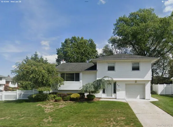 a front view of a house with a yard and potted plants