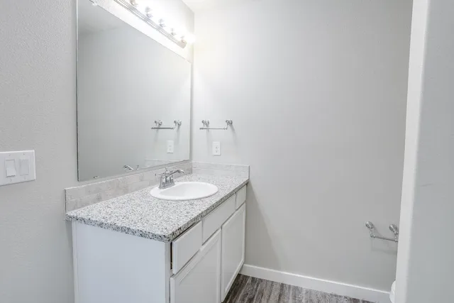 a bathroom with a granite countertop sink and a mirror
