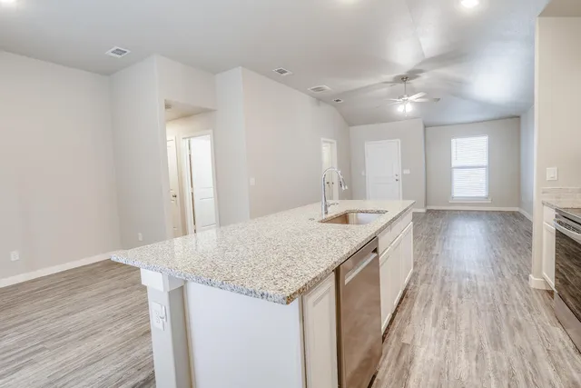 a kitchen with granite countertop a sink and wooden floor