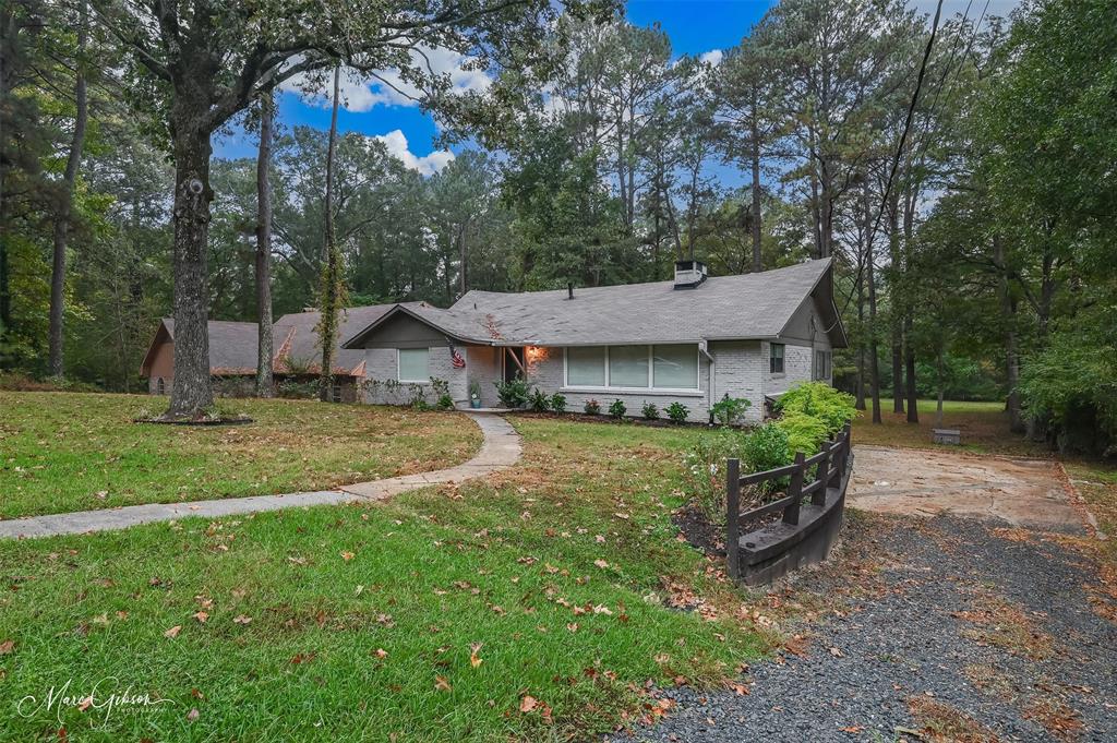 a view of a house with backyard and a tree
