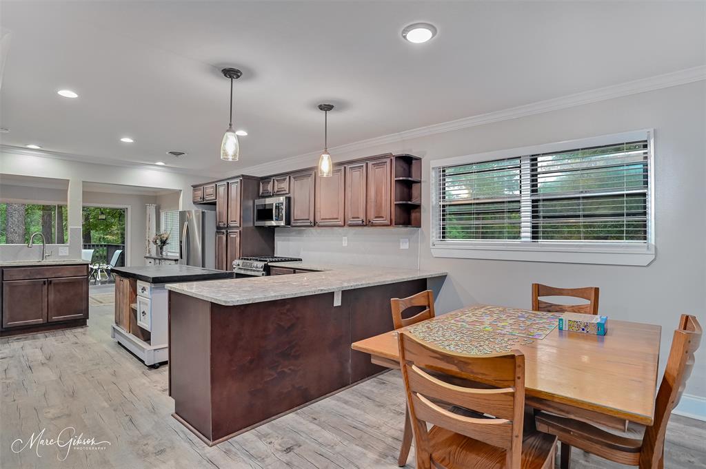 2912 Brookline Drive Shreveport, LA 71119 - Photo 6 of 27 a kitchen with stainless steel appliances granite countertop a stove top oven a sink dishwasher a dining table and chairs with wooden floor
