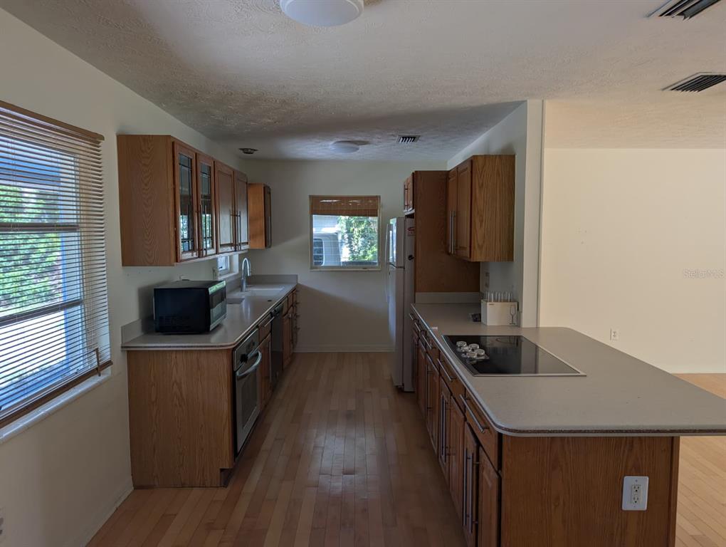 1176 40th Street Sarasota, FL 34234 - Photo 14 of 37 a kitchen with a stove sink and a refrigerator