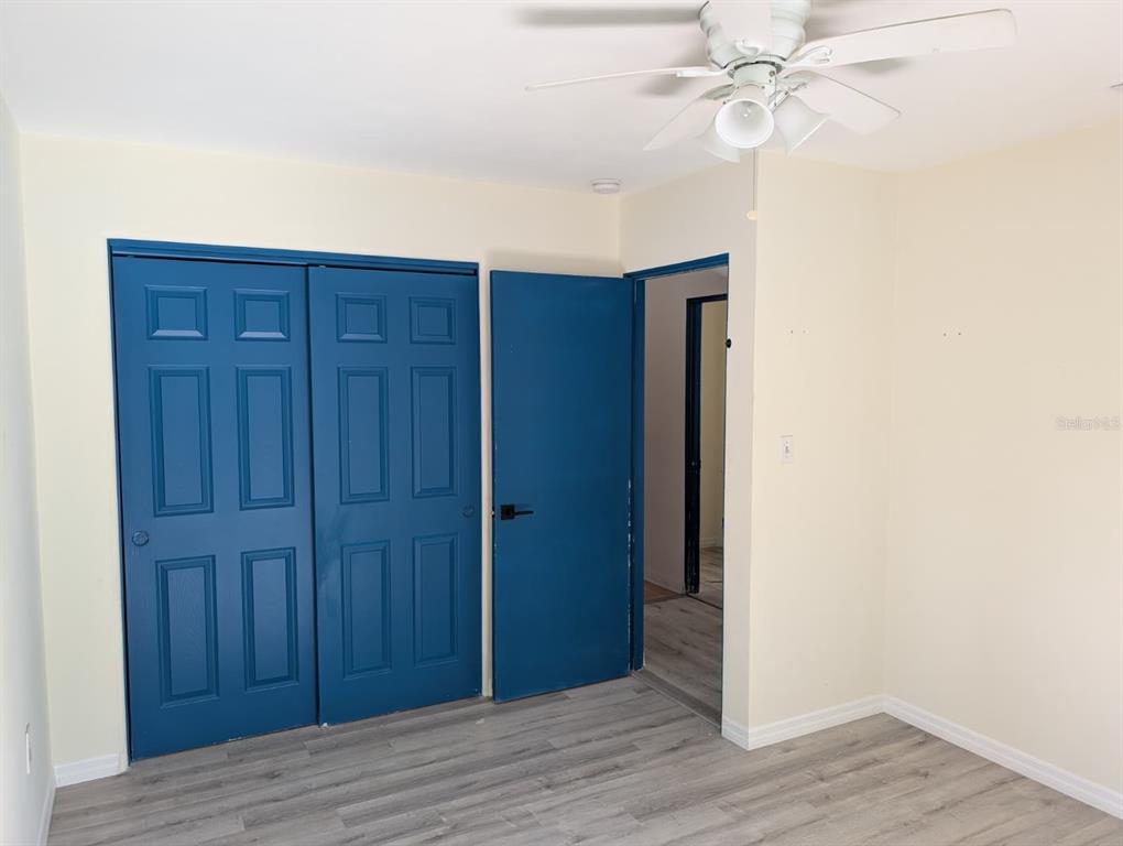 1176 40th Street Sarasota, FL 34234 - Photo 16 of 37 an empty room with wooden floor closet and fan