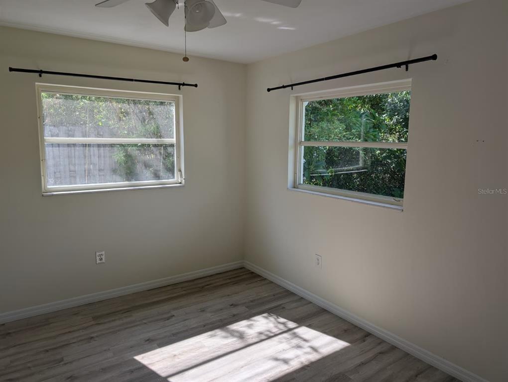 1176 40th Street Sarasota, FL 34234 - Photo 21 of 37 a view of empty room with wooden floor and windows