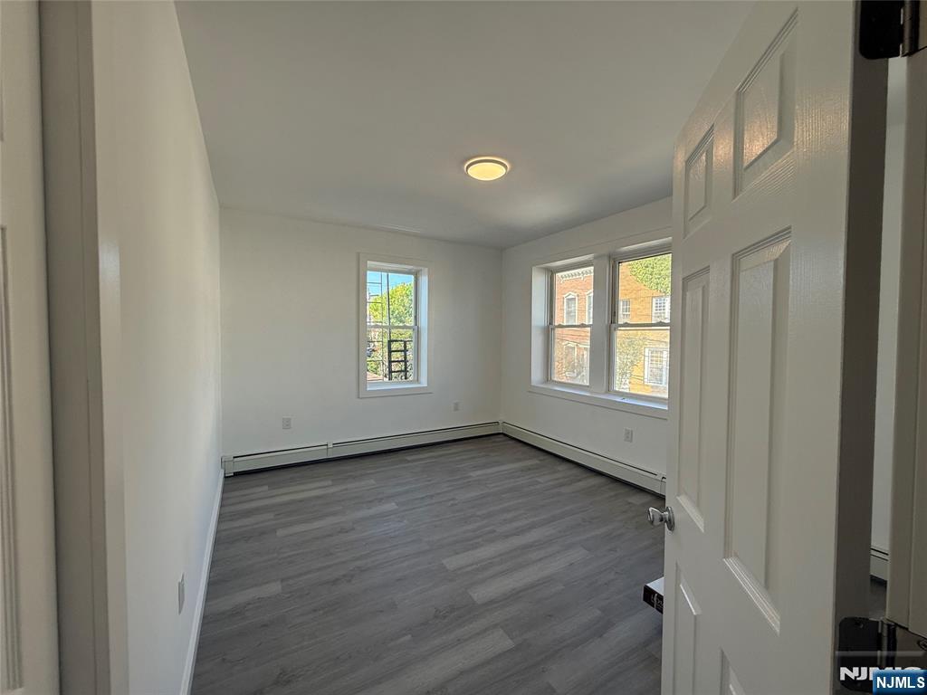 610 Gregory Avenue, Unit 2 Weehawken, NJ 07086 - Photo 13 of 18 a view of an empty room with a window and wooden floor