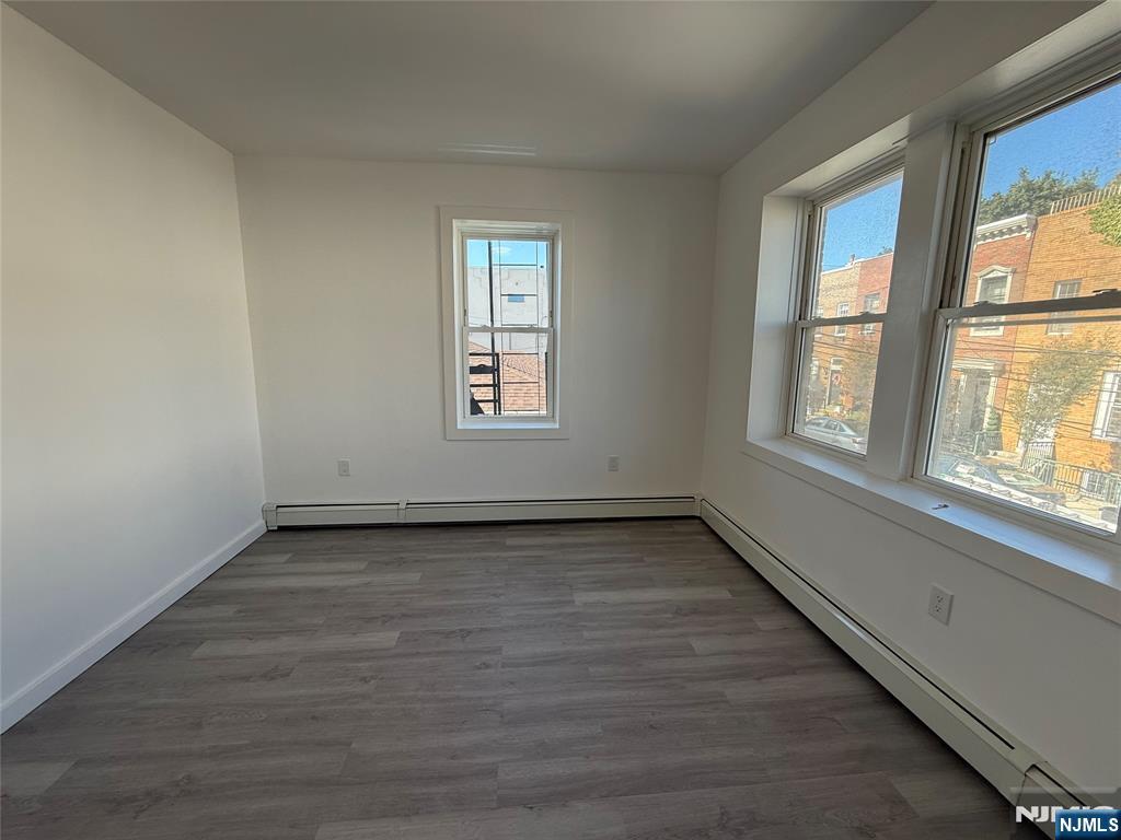 610 Gregory Avenue, Unit 2 Weehawken, NJ 07086 - Photo 14 of 18 an empty room with wooden floor and windows