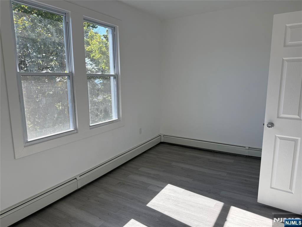 610 Gregory Avenue, Unit 2 Weehawken, NJ 07086 - Photo 16 of 18 an empty room with wooden floor and windows