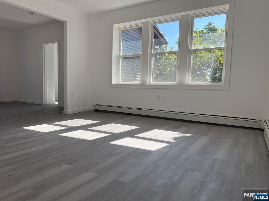 610 Gregory Avenue, Unit 2 Weehawken, NJ 07086 - Photo 3 of 18 an empty room with wooden floor and windows