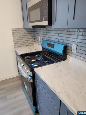 a kitchen with granite countertop a stove a sink and a microwave