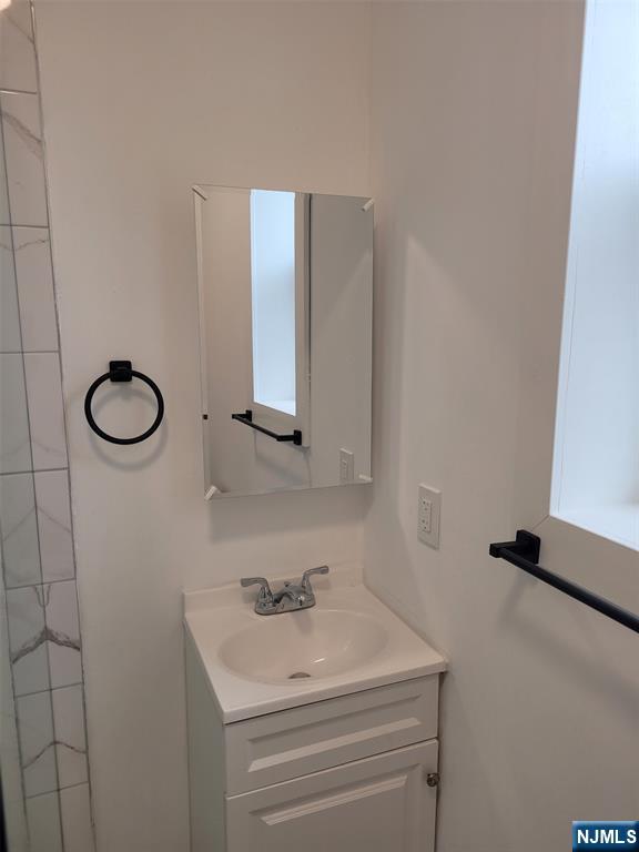 610 Gregory Avenue, Unit 2 Weehawken, NJ 07086 - Photo 9 of 18 a bathroom with a sink and a mirror