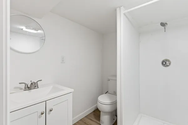 a bathroom with a toilet a sink and mirror