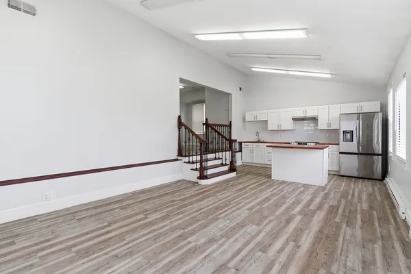 a view of a kitchen with wooden floor and electronic appliances