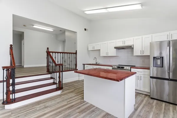 a kitchen with stainless steel appliances granite countertop a sink stove and refrigerator