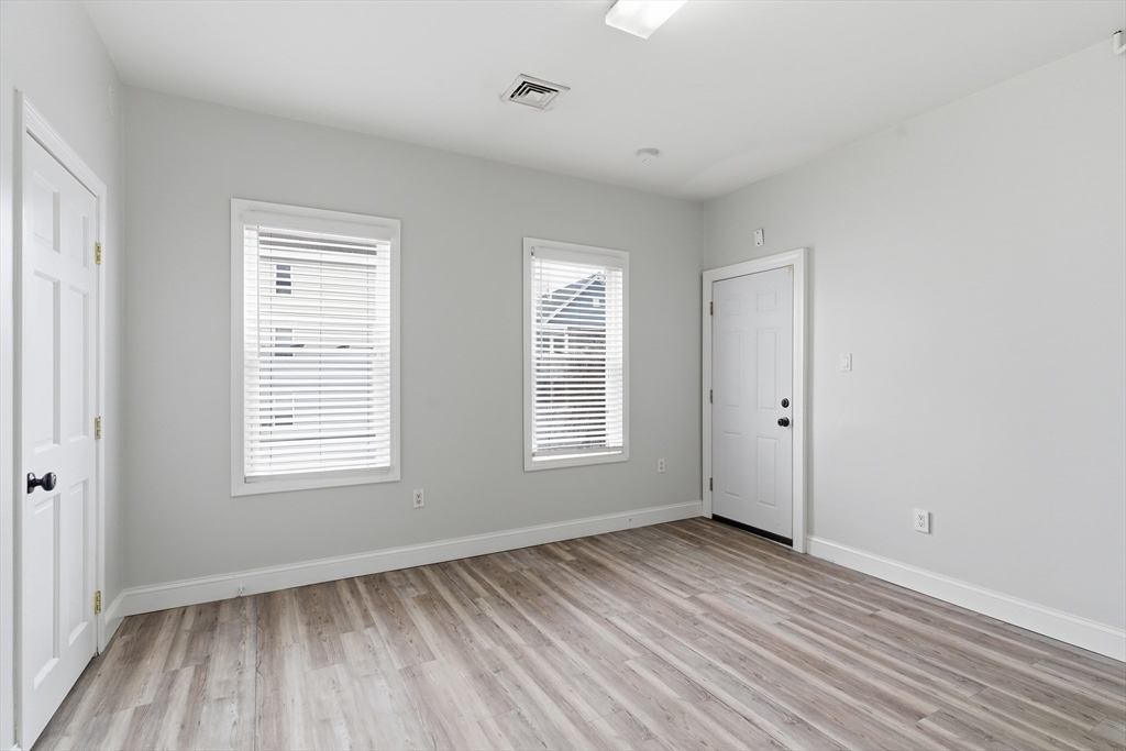 545 Brayton Avenue Fall River, MA 02721 - Photo 10 of 16 a view of an empty room with wooden floor and a window