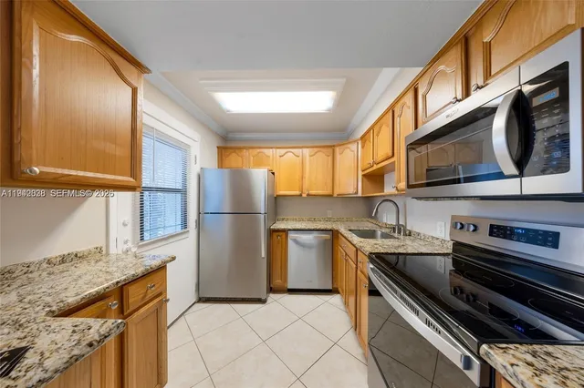 a kitchen with stainless steel appliances granite countertop a sink stove and cabinets