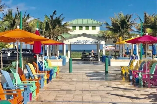 a view of the patio with dining table and chairs under an umbrella