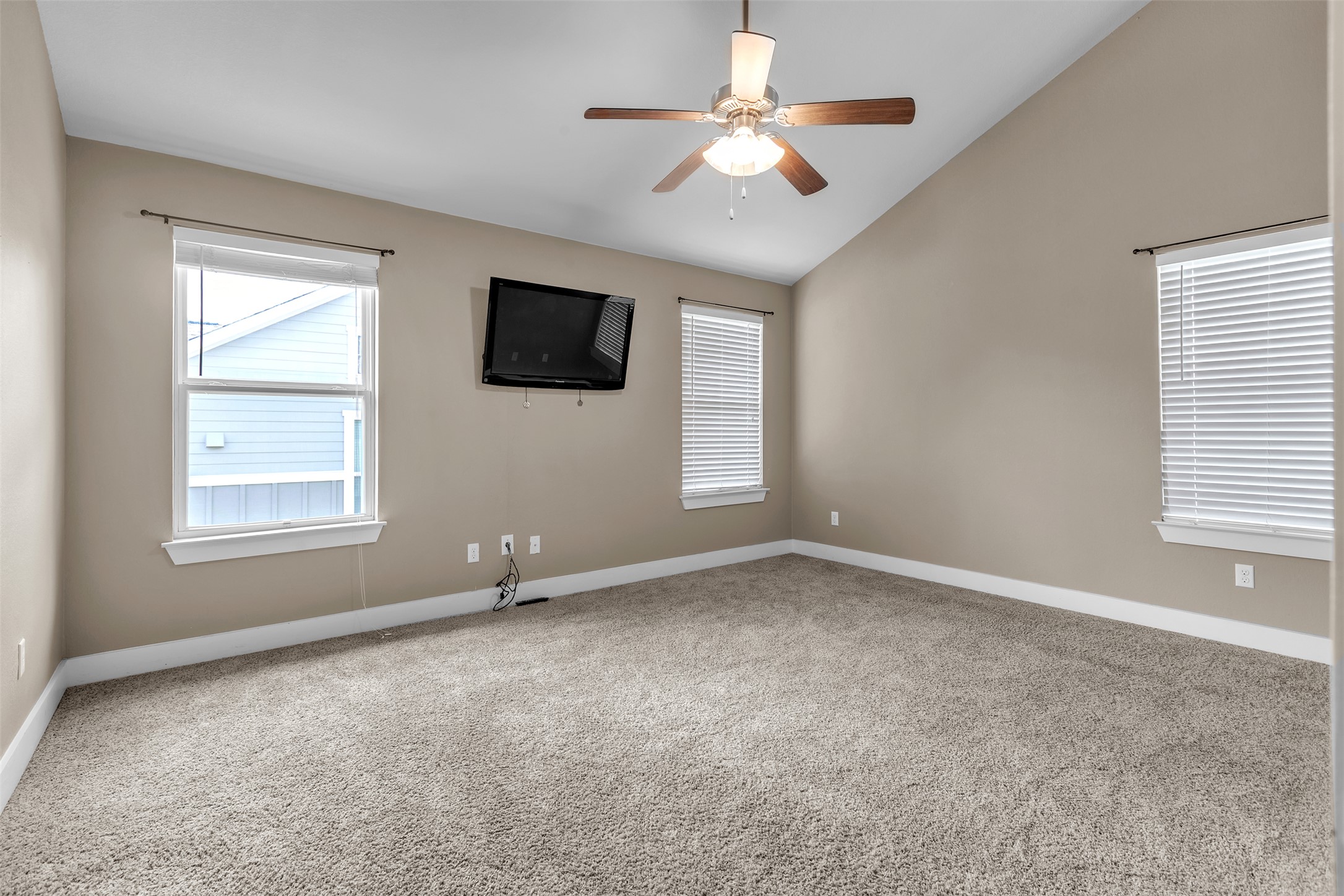12212 Tawny Farms Road, Unit 142 Austin, TX 78748 - Photo 9 of 21 A spacious primary bedroom features soft carpeting, a ceiling fan, and ample natural light from multiple windows.