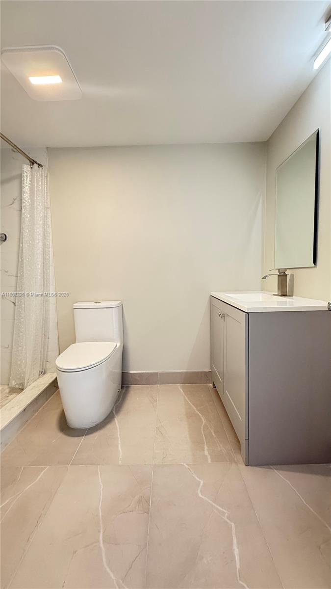 1750 Northeast 191st Street, Unit 7254 Miami, FL 33179 - Photo 14 of 16 a spacious bathroom with a toilet sink and mirror