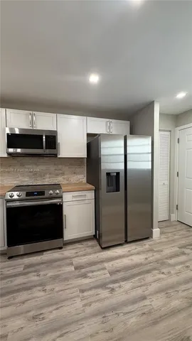 a kitchen with stainless steel appliances granite countertop a refrigerator and a stove top oven