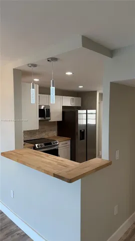 a large kitchen with stainless steel appliances a large counter top