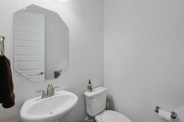 a bathroom with a sink mirror and toilet