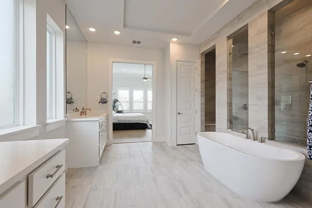 a bathroom with a double vanity sink a mirror and a bathtub