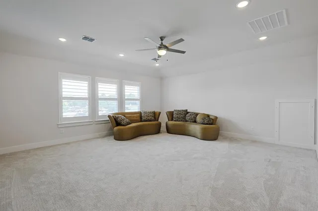 a living room with furniture ceiling fan and a window