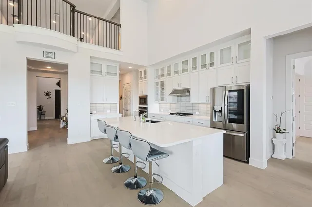 a large white kitchen with stainless steel appliances lots of counter space and breakfast area