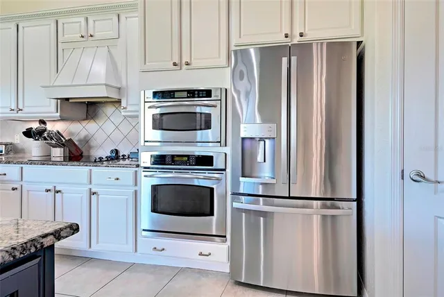 a kitchen with granite countertop a sink stainless steel appliances and cabinets