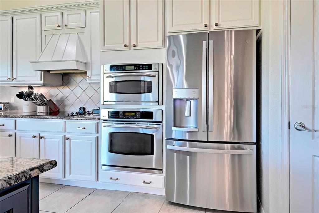 12086 Granite Woods Loop Venice, FL 34292 - Photo 14 of 85 a kitchen with stainless steel appliances granite countertop a refrigerator stove and white cabinets