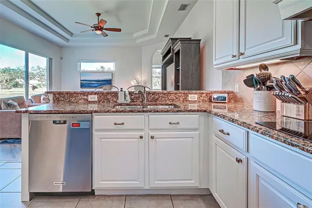 a kitchen with stainless steel appliances a dining table chairs and granite counter tops