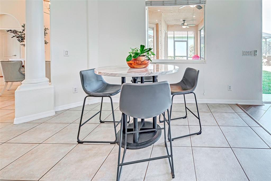 12086 Granite Woods Loop Venice, FL 34292 - Photo 19 of 85 a dining room with furniture and a potted plant