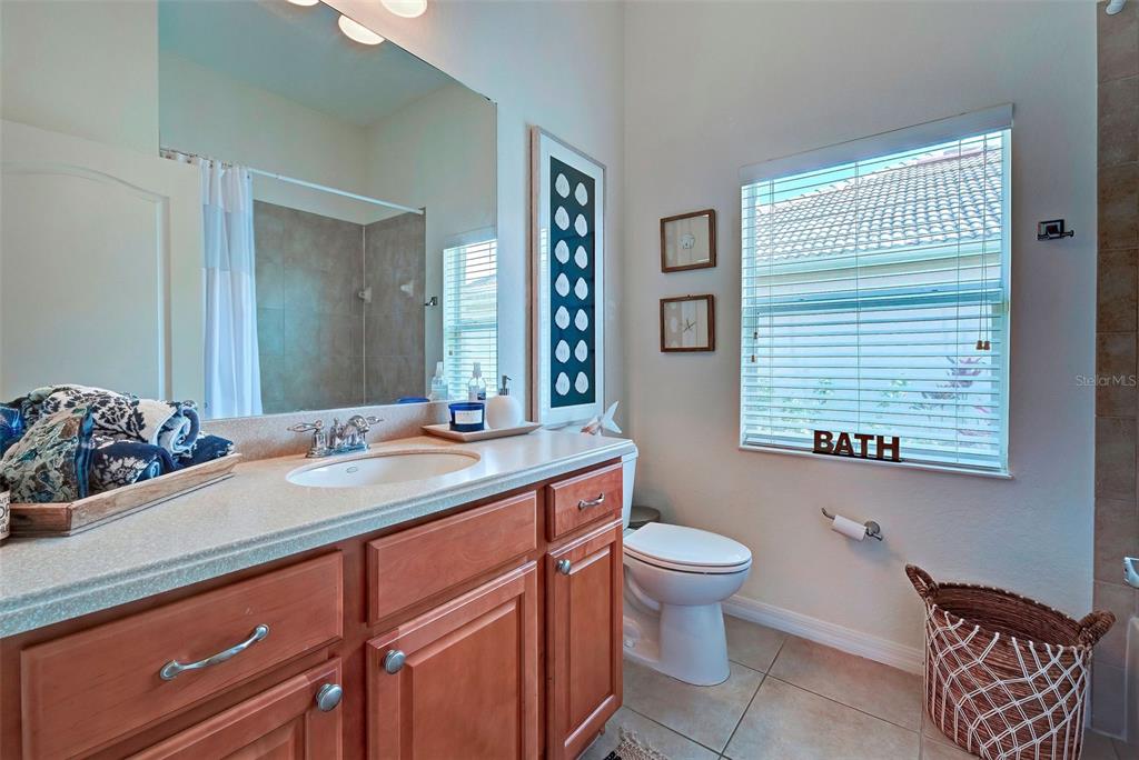 12086 Granite Woods Loop Venice, FL 34292 - Photo 42 of 85 a bathroom with a granite countertop sink toilet and mirror