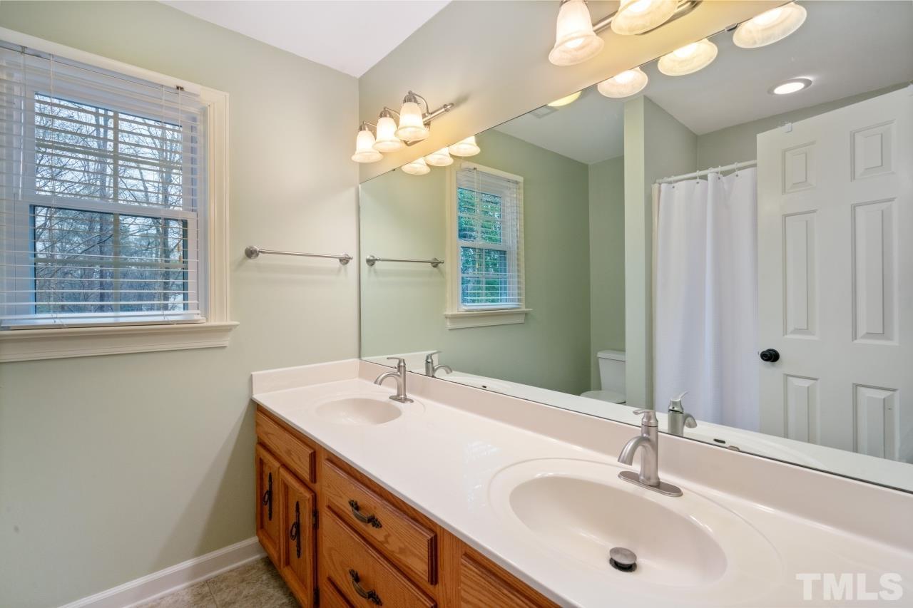 1604 Habbot Drive Raleigh, NC 27603 - Photo 23 of 35 a bathroom with a double vanity sink and a mirror