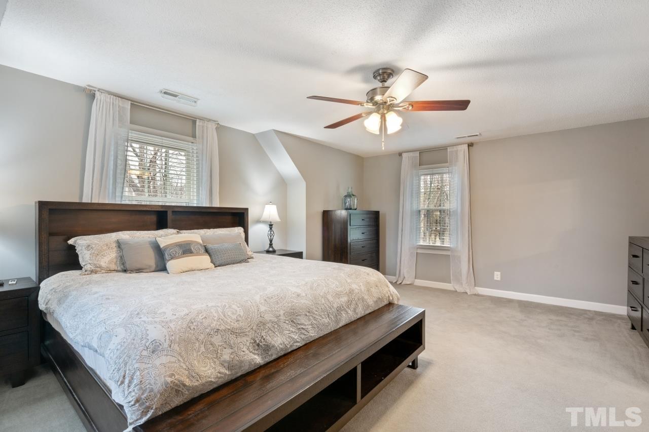 1604 Habbot Drive Raleigh, NC 27603 - Photo 30 of 35 a bedroom with a large bed chandelier and a window