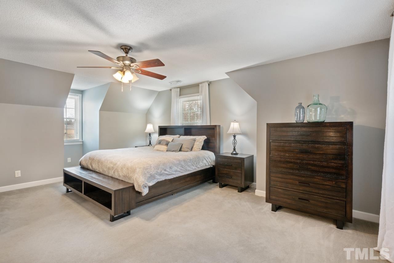 1604 Habbot Drive Raleigh, NC 27603 - Photo 32 of 35 a spacious bedroom with a bed and a chandelier