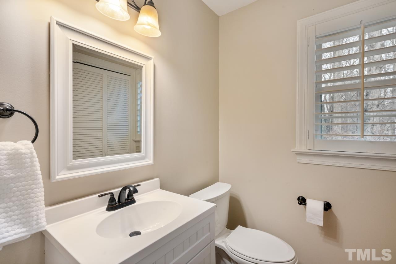 1604 Habbot Drive Raleigh, NC 27603 - Photo 8 of 35 a bathroom with a toilet sink vanity and mirror