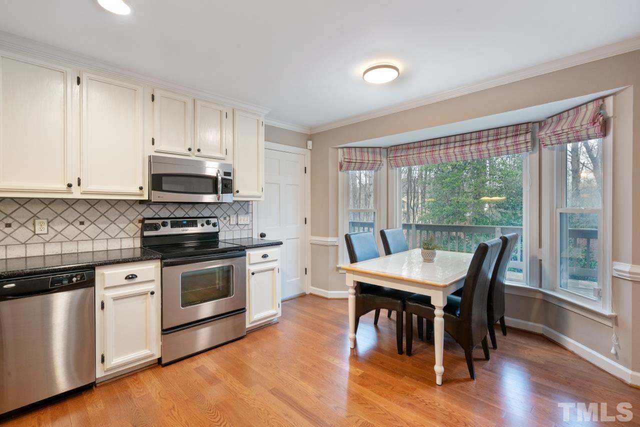 1604 Habbot Drive Raleigh, NC 27603 - Photo 9 of 35 a kitchen with stainless steel appliances granite countertop a stove a refrigerator a white table and chairs