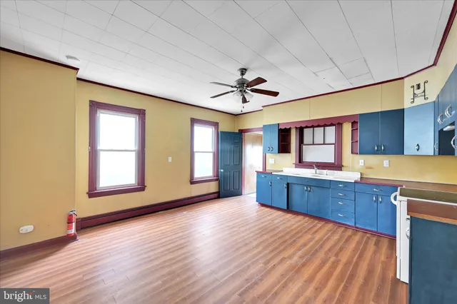 a large kitchen with wooden floors and stainless steel appliances