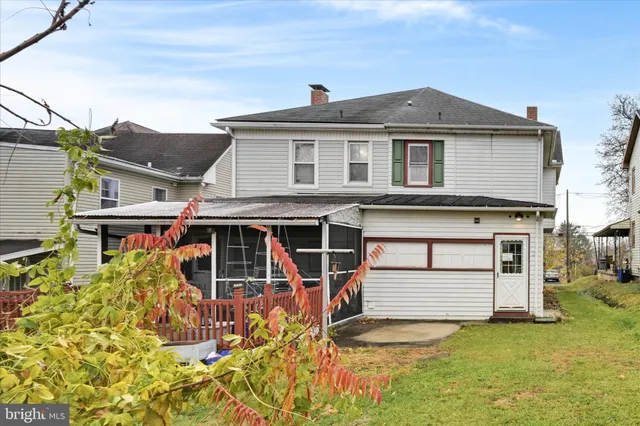 a view of a house with a big yard and large trees