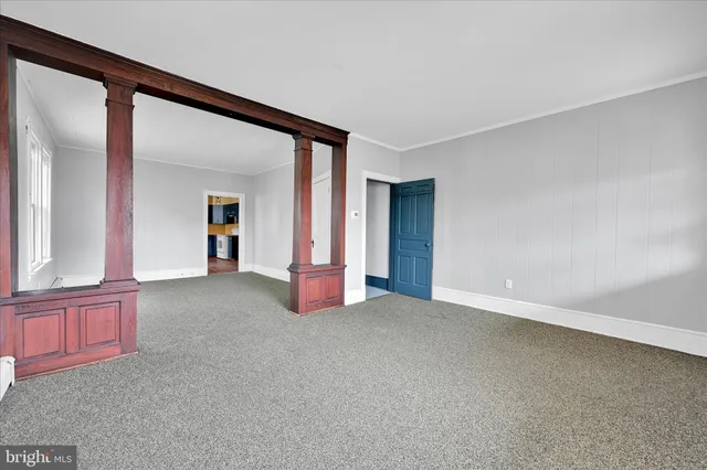 an empty room with a fireplace and windows