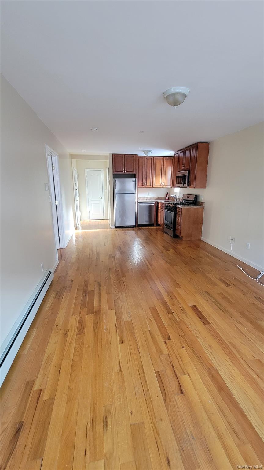 108-27 63rd Avenue, Unit 3B Queens, NY 11375 - Photo 3 of 17 a room with wooden floor and furniture