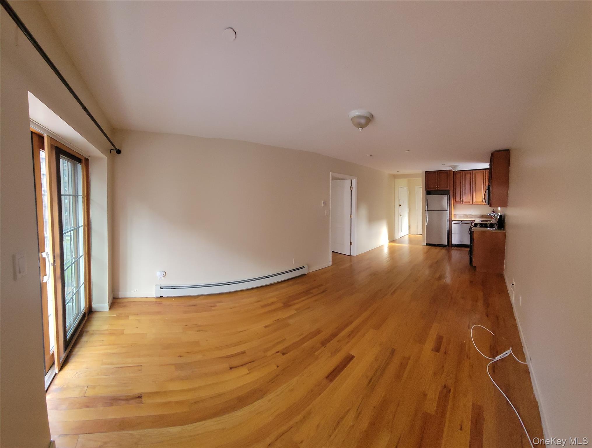 108-27 63rd Avenue, Unit 3B Queens, NY 11375 - Photo 5 of 17 a view of empty room with wooden floor and a window