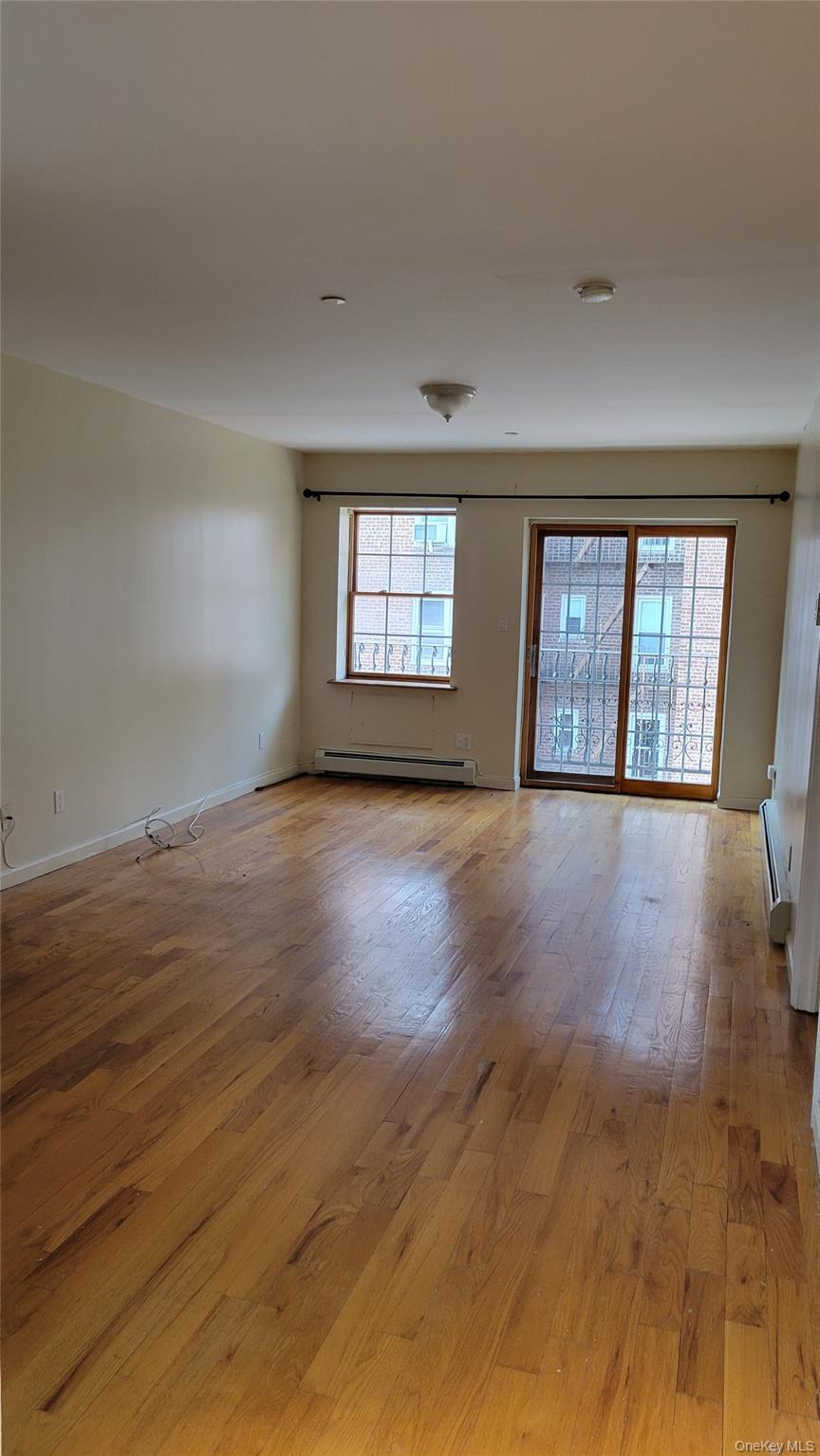 108-27 63rd Avenue, Unit 3B Queens, NY 11375 - Photo 6 of 17 a view of an empty room with wooden floor and a window